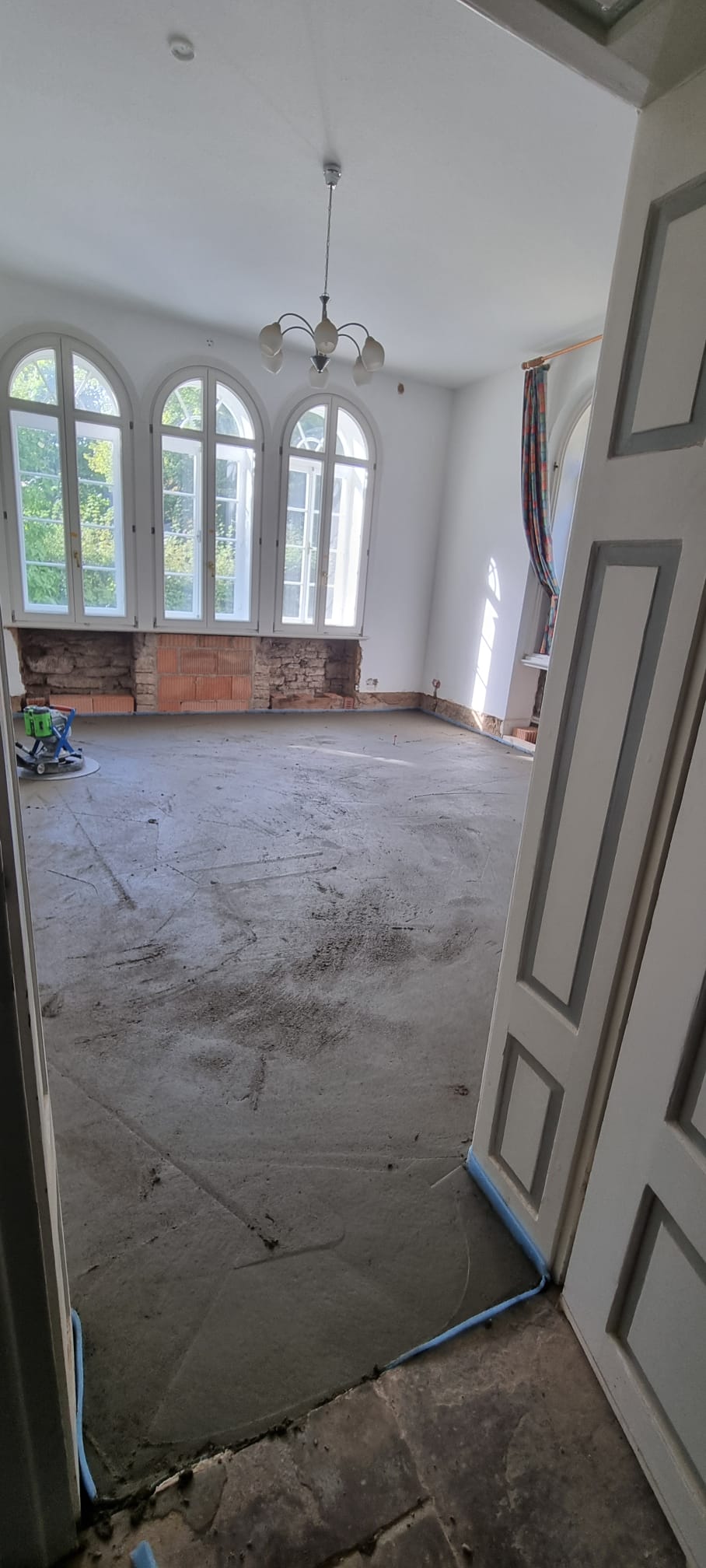 Der fertig gegossene und geglättete Estrichboden im Raum mit Bogenfenstern